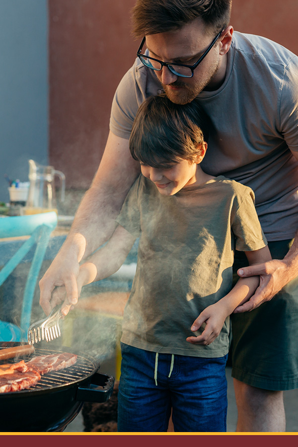 Dad and son at the grill